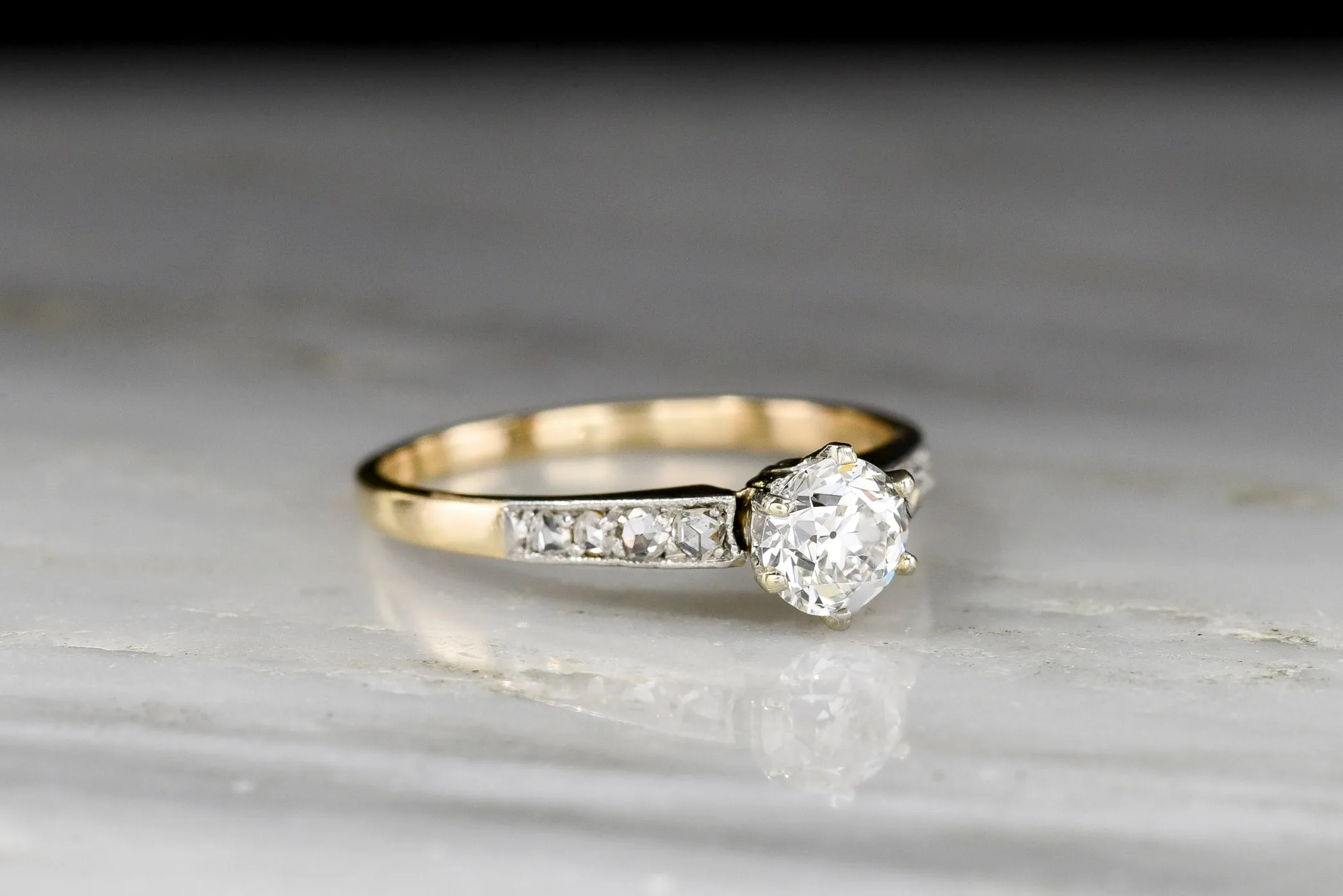 c. 1900s Gold and Platinum Ring with an Old European Cut Diamond Center and Antique Rose Cut Accents